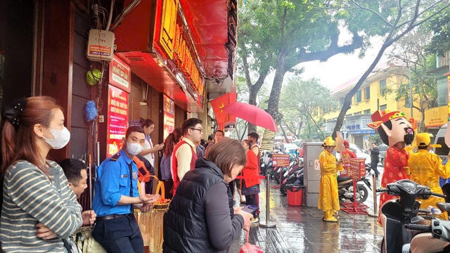 Người dân đội mưa xếp hàng mua vàng trước ngày vía Thần Tài