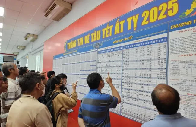 Hành khách xem thông tin về thời gian chạy và vé tàu Tết. Ảnh: PLO
