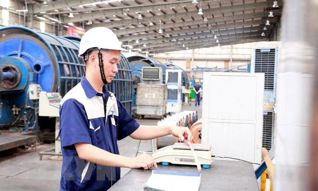 Kỹ sư Nguyễn Văn Tuân kiểm tra tỷ trọng cáp điện, một trong những hoạt động của nghiên cứu để giảm tỷ trọng lõi dẫn, giảm giá thành sản xuất cáp điện. (Ảnh: Minh Thu/TTXVN)