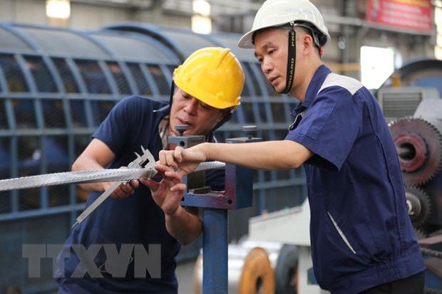 Kỹ sư Nguyễn Văn Tuân (phải) luôn sát sao trong quá trình triển khai sáng kiến để khắc phục kịp thời những kỹ thuật chưa hoàn hảo. (Ảnh: Minh Thu/TTXVN)