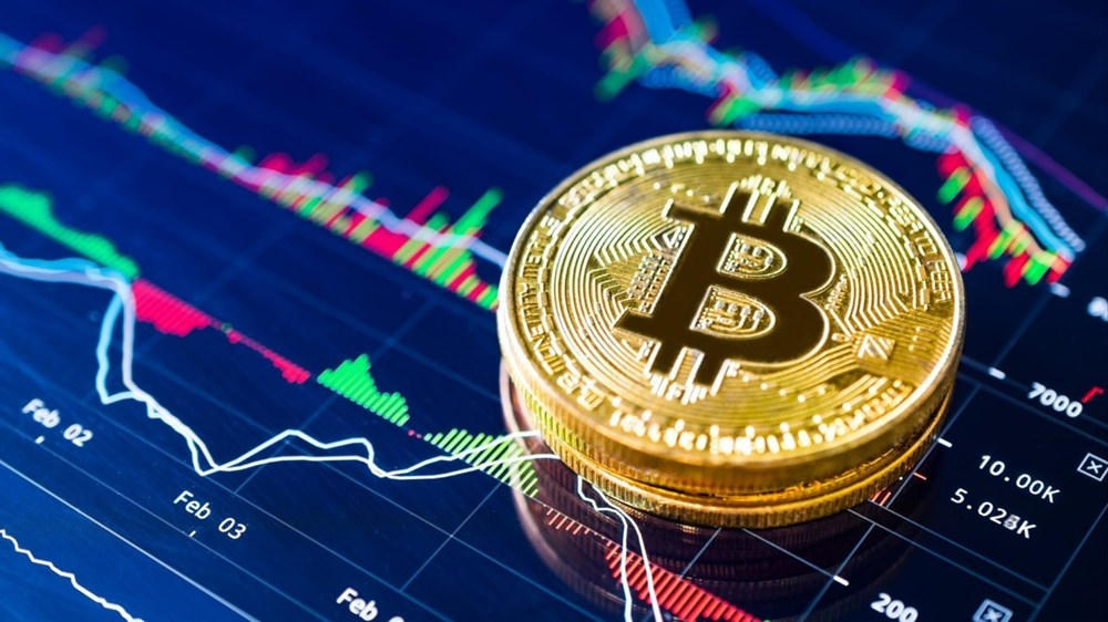 Đồng xu biểu tượng Bitcoin trước biểu đồ diễn biến giá.