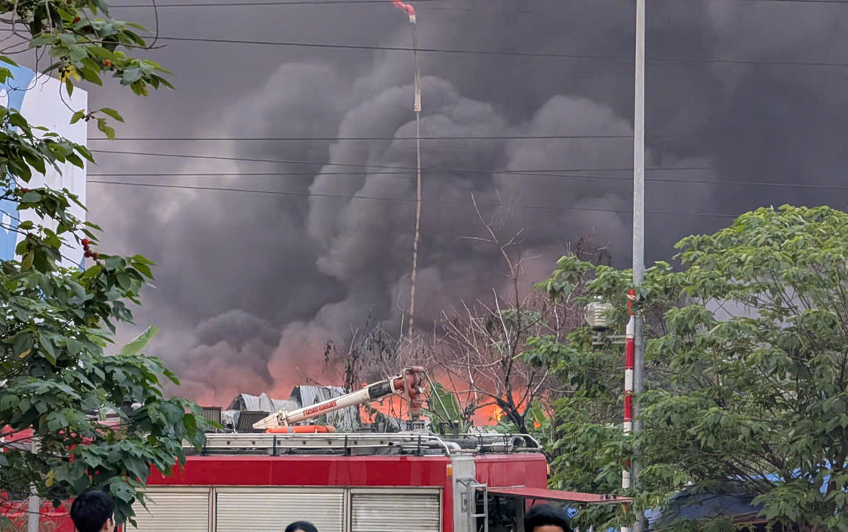 Lửa bao trùm toàn bộ khu nhà xưởng, cột khói cao hàng chục mét.