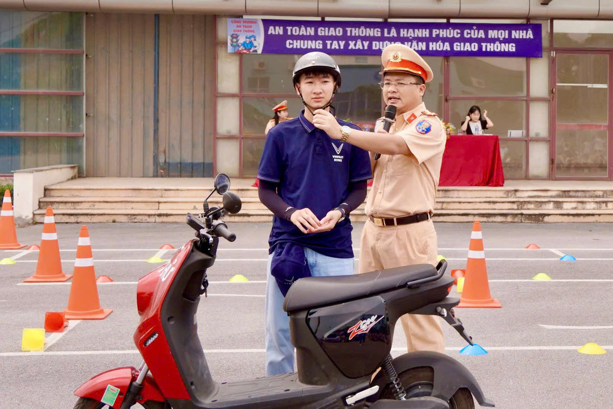 CSGT hướng dẫn học sinh đội mũ bảo hiểm đúng quy cách.