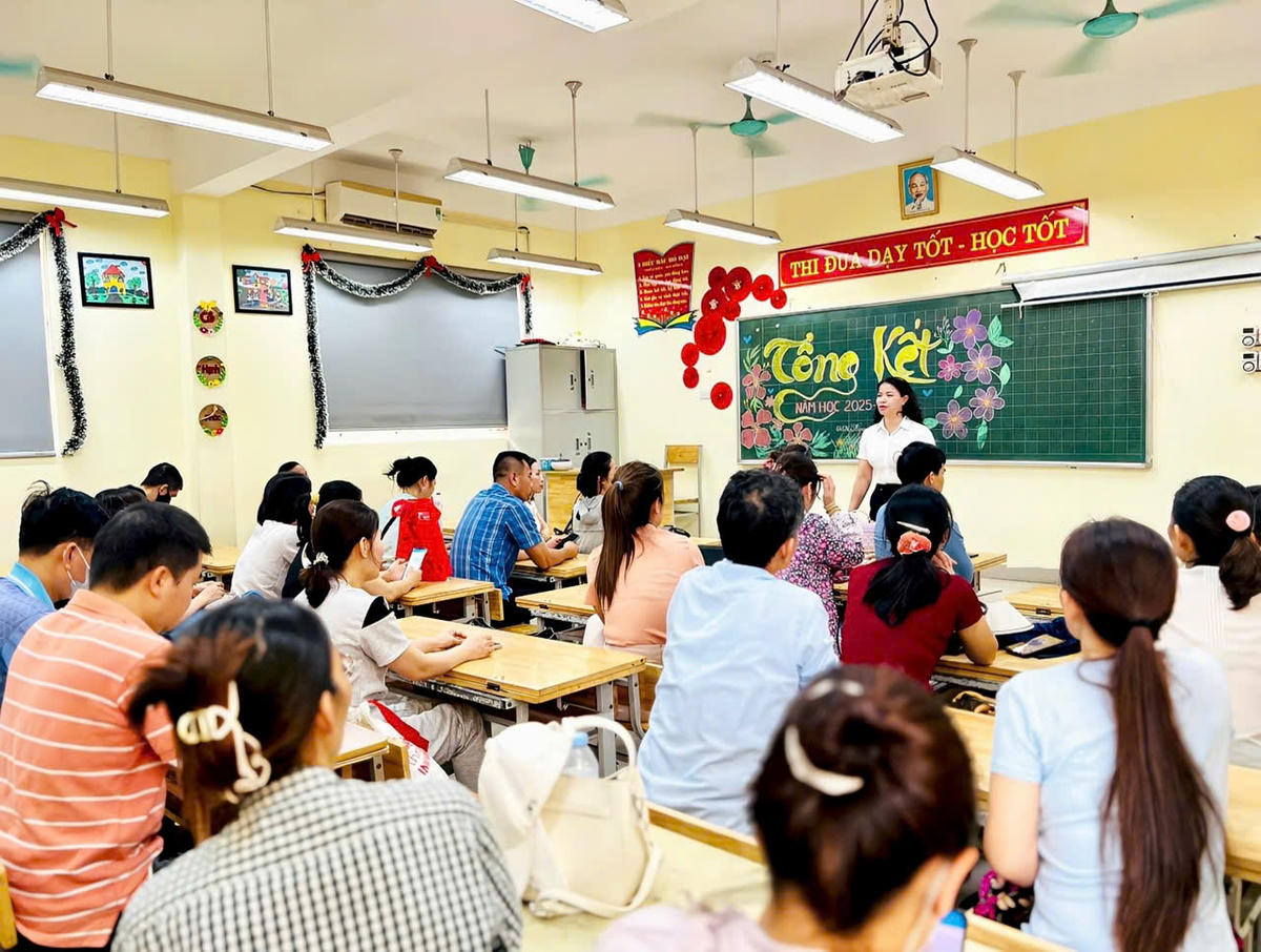 Giáo viên Trường Tiểu học Thị trấn Yên Viên hướng dẫn, hỗ trợ phụ huynh tại phòng học được bố trí làm nơi nghỉ ngơi trong thời gian chờ thí sinh dự Kỳ thi tốt nghiệp THPT năm 2026.