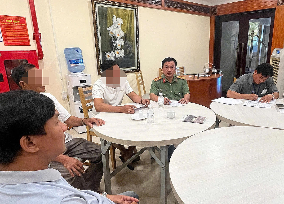 Lực lượng chức năng làm việc với hai du khách bẻ san hô ở biển Hòn Chồng. Ảnh: Minh Khuê/VnExpress