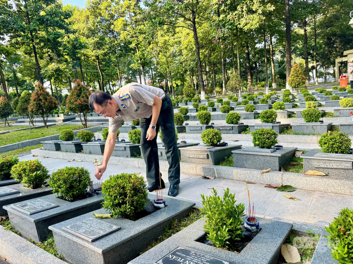 Lãnh đạo Phòng Thi hành án dân sự Khu vực 15 thắp nhang ở từng phần mộ liệt sĩ trong khuôn viên nghĩa trang để bày tỏ lòng tôn kính và tri ân sâu sắc đối với các anh hùng, liệt sĩ.
