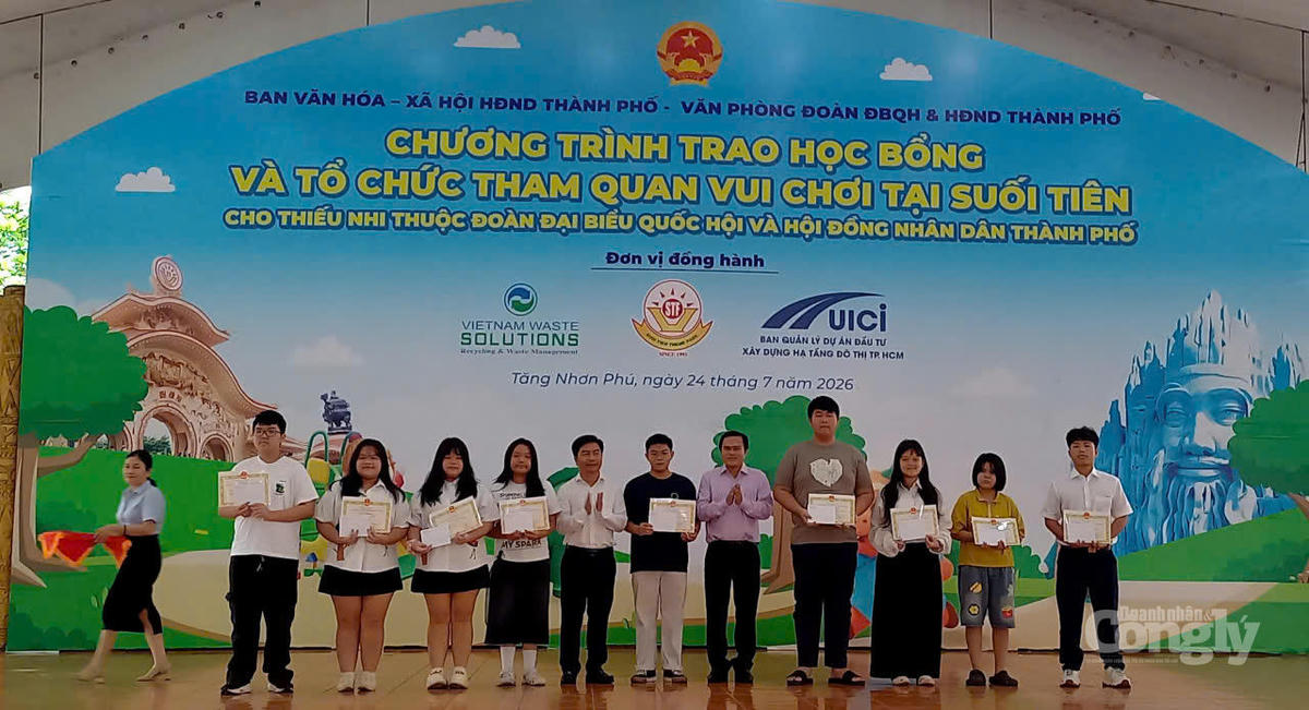 Trưởng Ban Văn hóa – Xã hội HĐND TP.HCM Cao Thanh Bình (thứ 5 từ phải sang) trao học bổng và giấy khen cho các em học sinh.