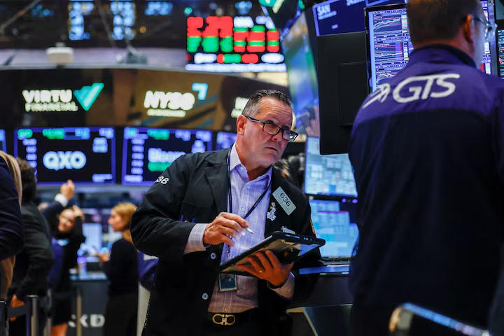 Các nhà giao dịch làm việc trên sàn New York Stock Exchange (NYSE) tại New York, Mỹ. Ảnh: Reuters.