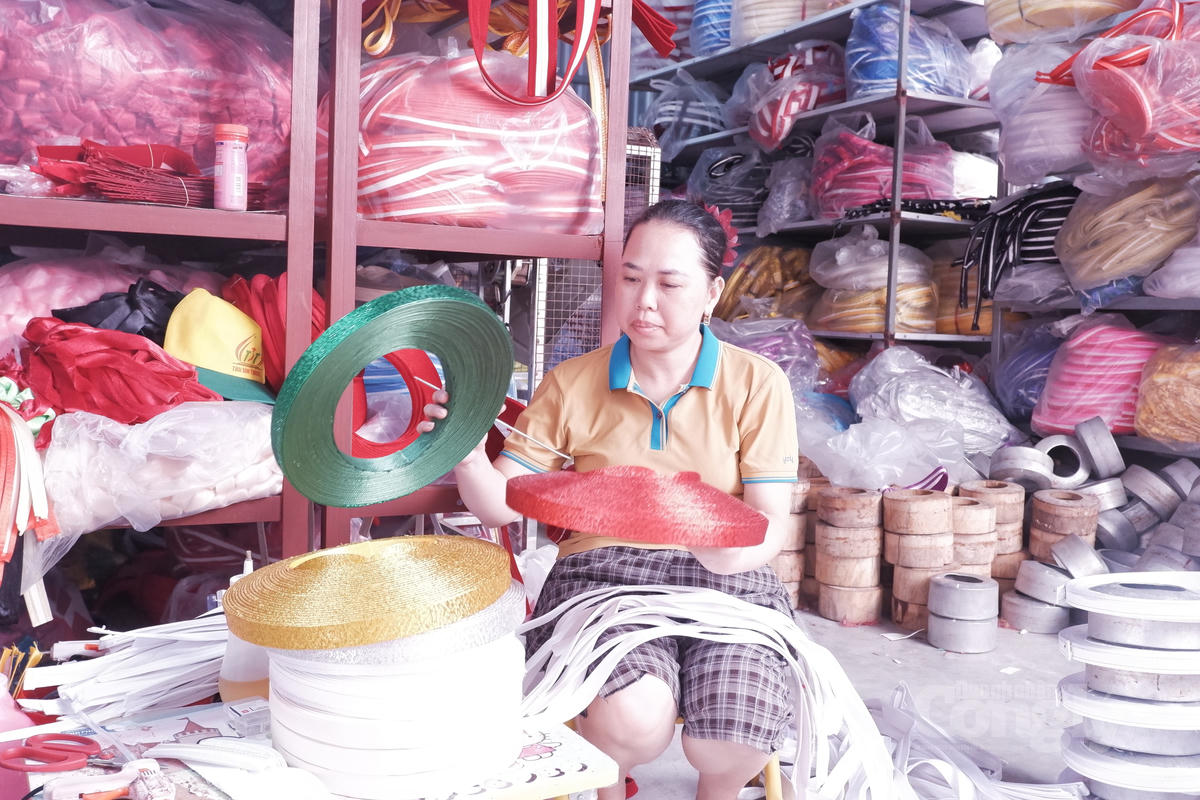 Nghệ nhân Vũ Thị Yến kiểm tra những chiếc khăn xếp đang được hoàn thiện tại cơ sở sản xuất.