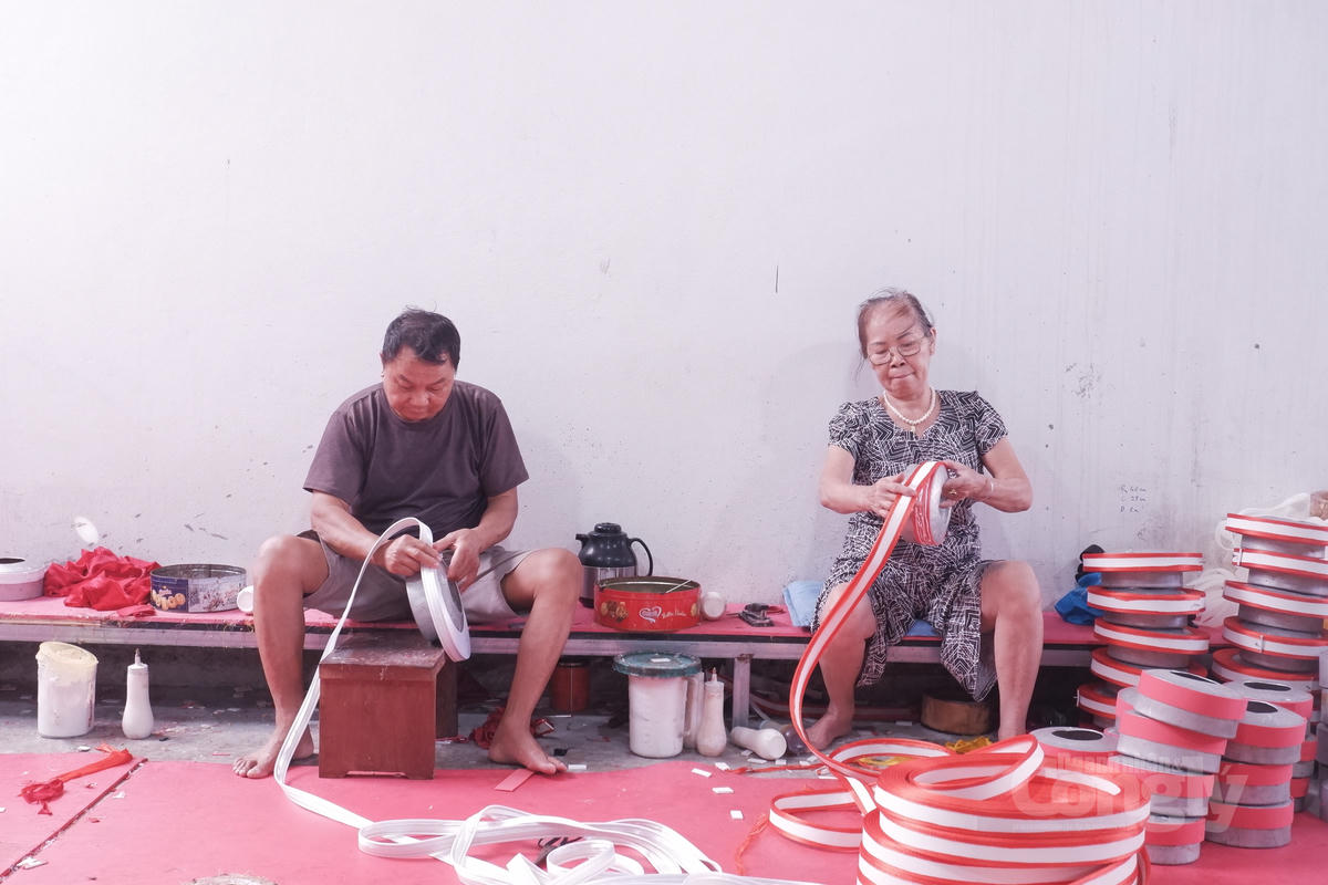 Những người thợ tại thôn Giáp Nhất thực hiện công đoạn quấn và tạo nếp khăn xếp bằng tay.