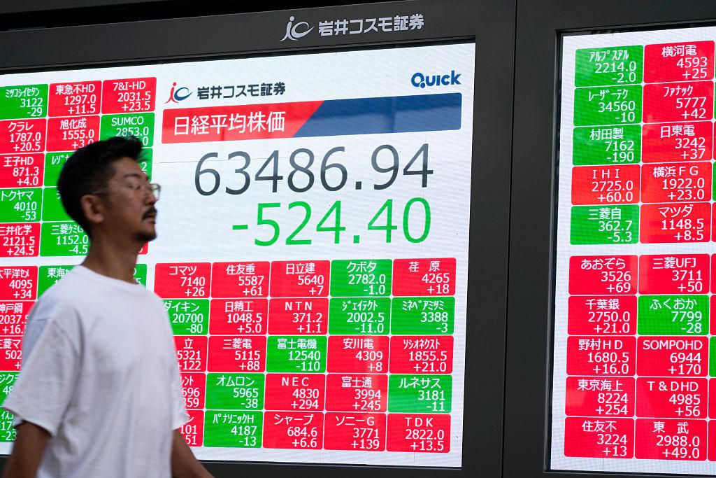 Người dân đi qua bảng điện tử hiển thị chỉ số Nikkei tại Tokyo, Nhật Bản. Ảnh: AFP/Yuichi Yamazaki